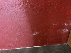 Présence de salpêtre sur un mur rouge